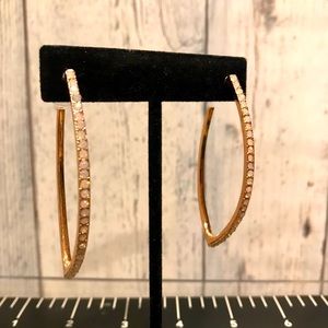 Rose gold pointed hoop earrings .